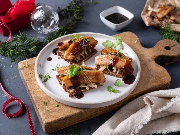 Ribberester på en hvit tallerken med granbar og julepynt rundt, på et trebenet skjærebrett.