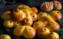 Lussekatter formet som små katter og med rosiner som øyne, ligger på et fat.