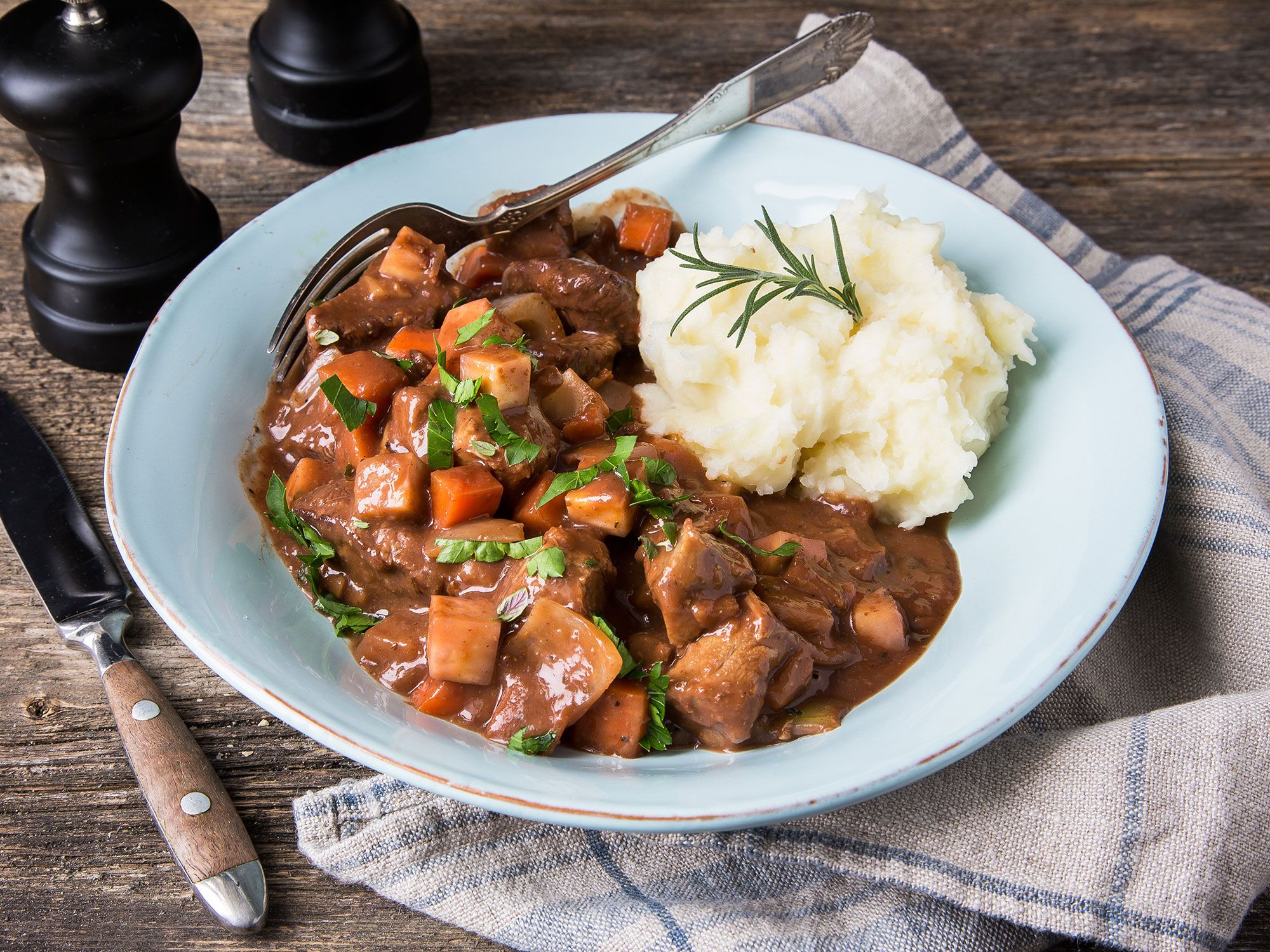 Lammegryte med grønnsaker og potetmos på en hvit tallerken, ser ut til å være en Provence-inspirert rett.