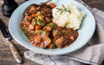 Lammegryte med grønnsaker og potetmos på en hvit tallerken, ser ut til å være en Provence-inspirert rett.