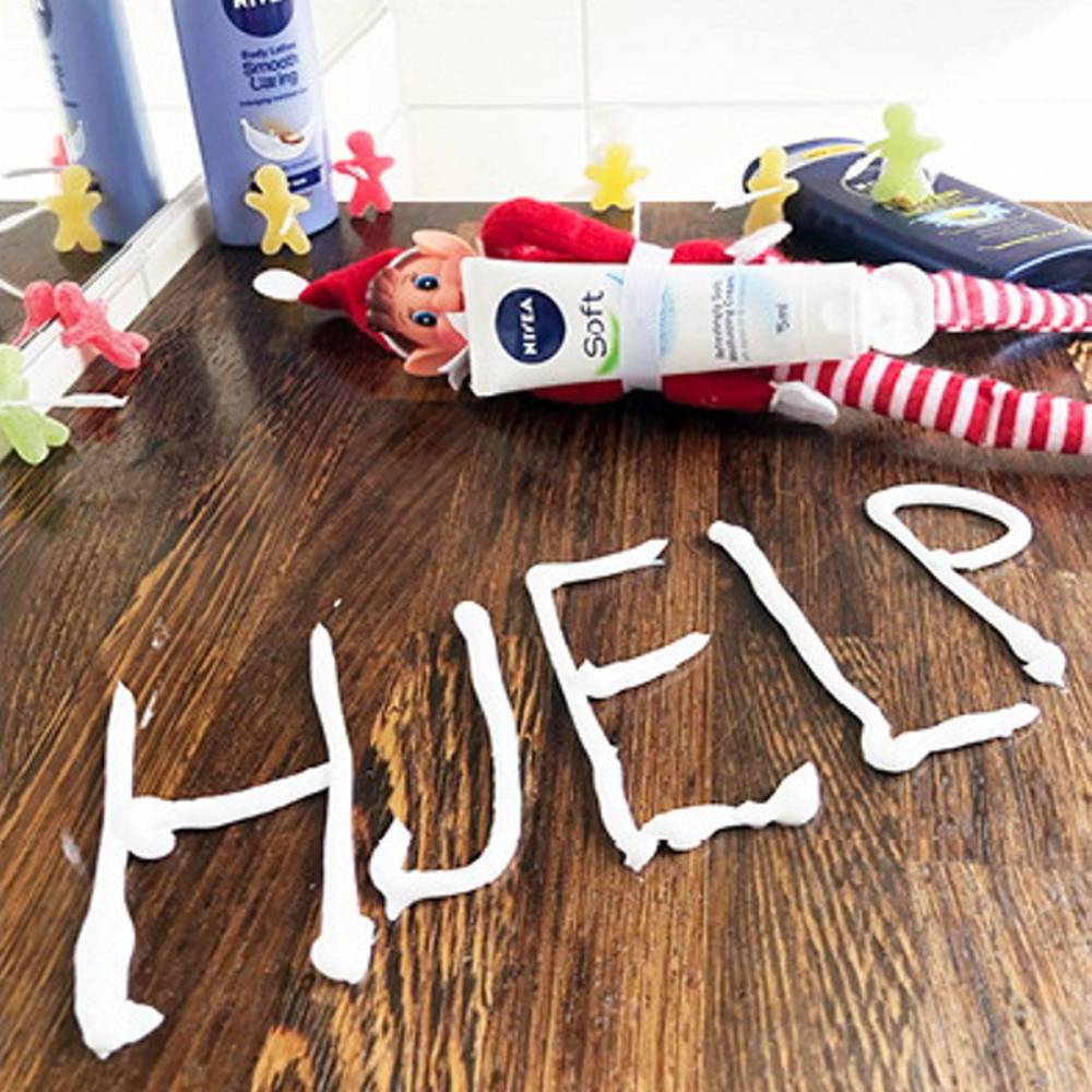 En rekke små rampenisser i ulike farger plassert på en bordflate med en vegg i bakgrunnen.