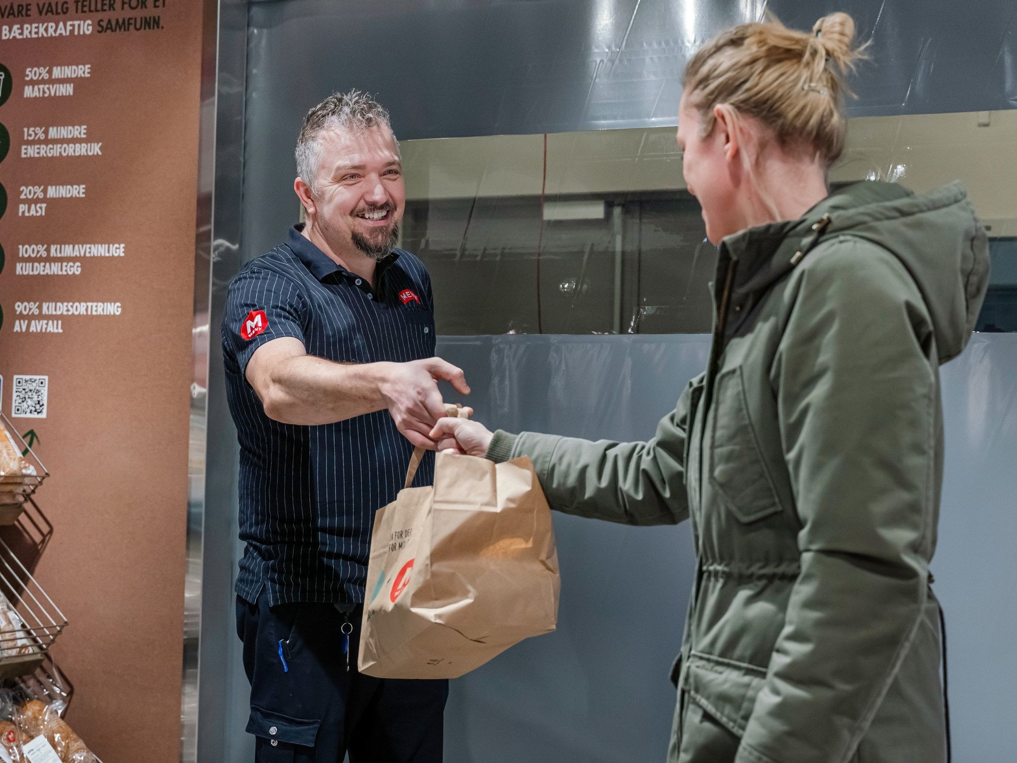 MENY-ansatt overleverer en Too Good To Go-pose til kunde.