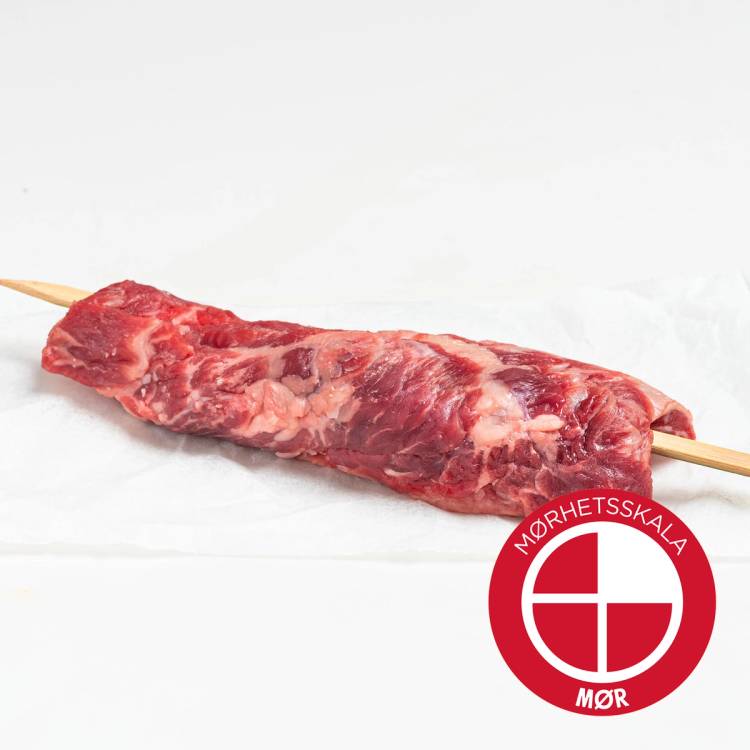 En skive av rått kjøtt på en trepinne, med en Mørhetsskala-merke i hjørnet.