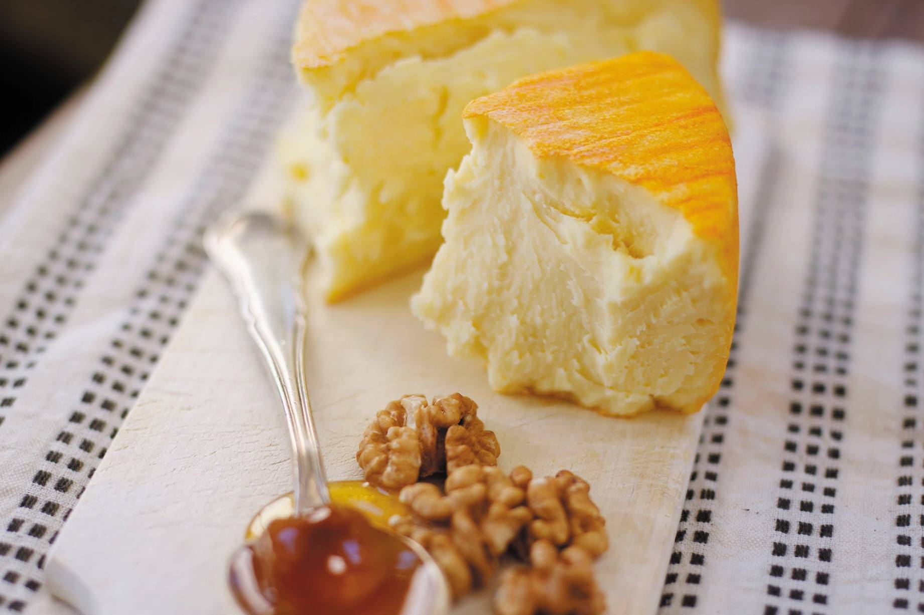 Et stykke ridderost med en skive på, ser ut til å være servert med nøtter og honning på en tallerken.