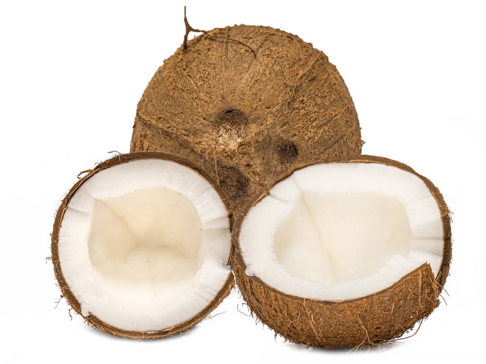 To kokosnøtter, en hel og en delt i to, med hvitt kjøtt inni, ligger på en hvit bakgrunn.