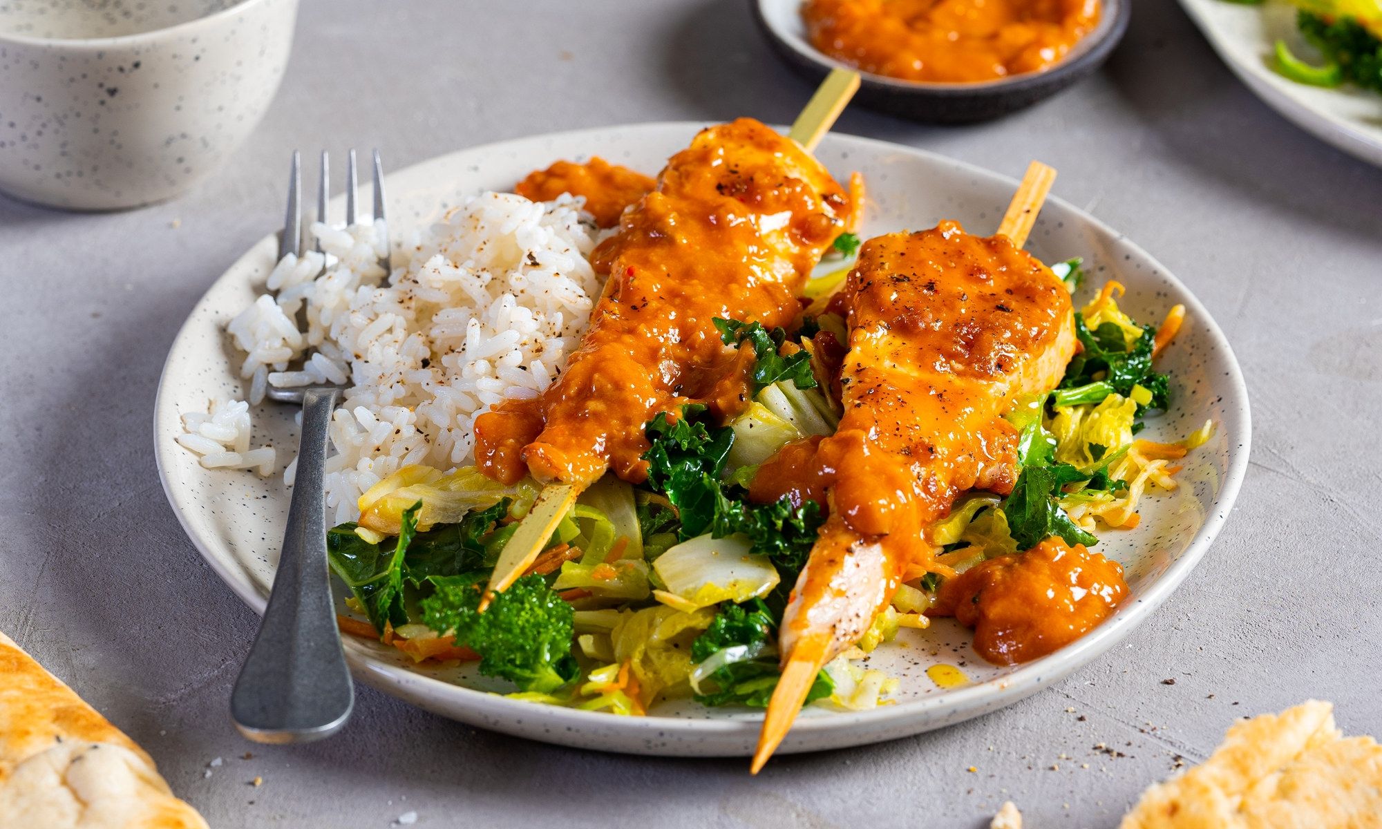 Kylling satay med ris og grønnsaker på en tallerken, ser ut til å være ukens middag.