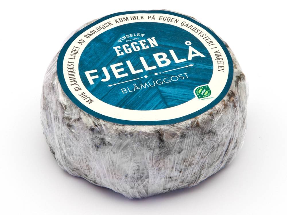 En ost med blåmuggost fra Eggen Fjellblå, pakket inn i papir med blå etikett på toppen.