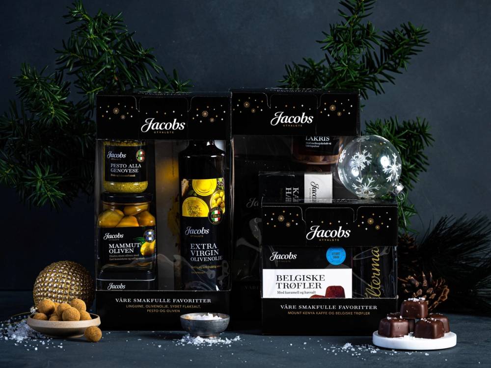 Ulike Jacobs gaveesker og sjokoladeplater på et bord med juledekorasjoner og grønne grener