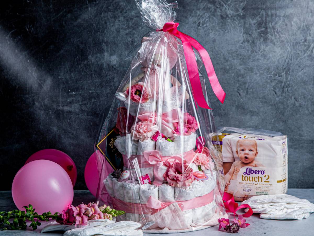 Bleiekake med bleier, blomster og rosa sløyfer.