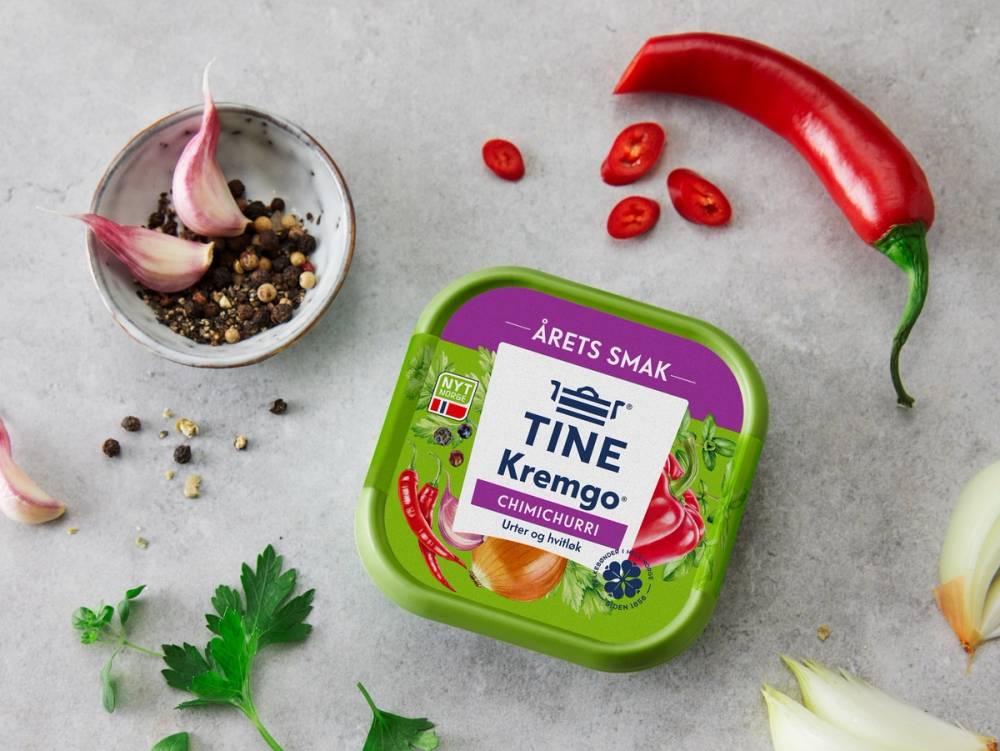 Kremost med smak av chimichurri omgitt av chili, hvitløk, pepper og urter på en lys bakgrunn