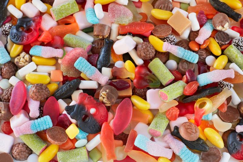 Fargerikt utvalg av smågodt i ulike former og farger, inkludert lakris, gele og sjokoladebiter.