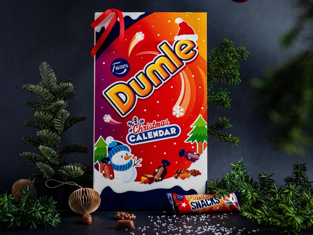 En julekalender med Dumle-figur på forsiden, omgitt av julegrener og sjokolade, med en julehatt på toppen.