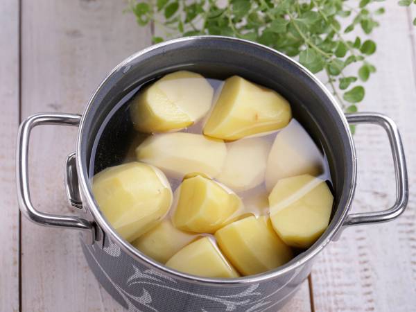 Poteter som kokes i en kjele med vann, klare til å bli spist.
