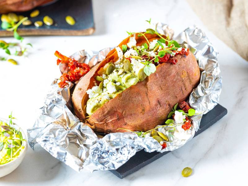 Bakt potet fylt med avokado, fetaost og grønne urter, pakket inn i aluminiumsfolie.