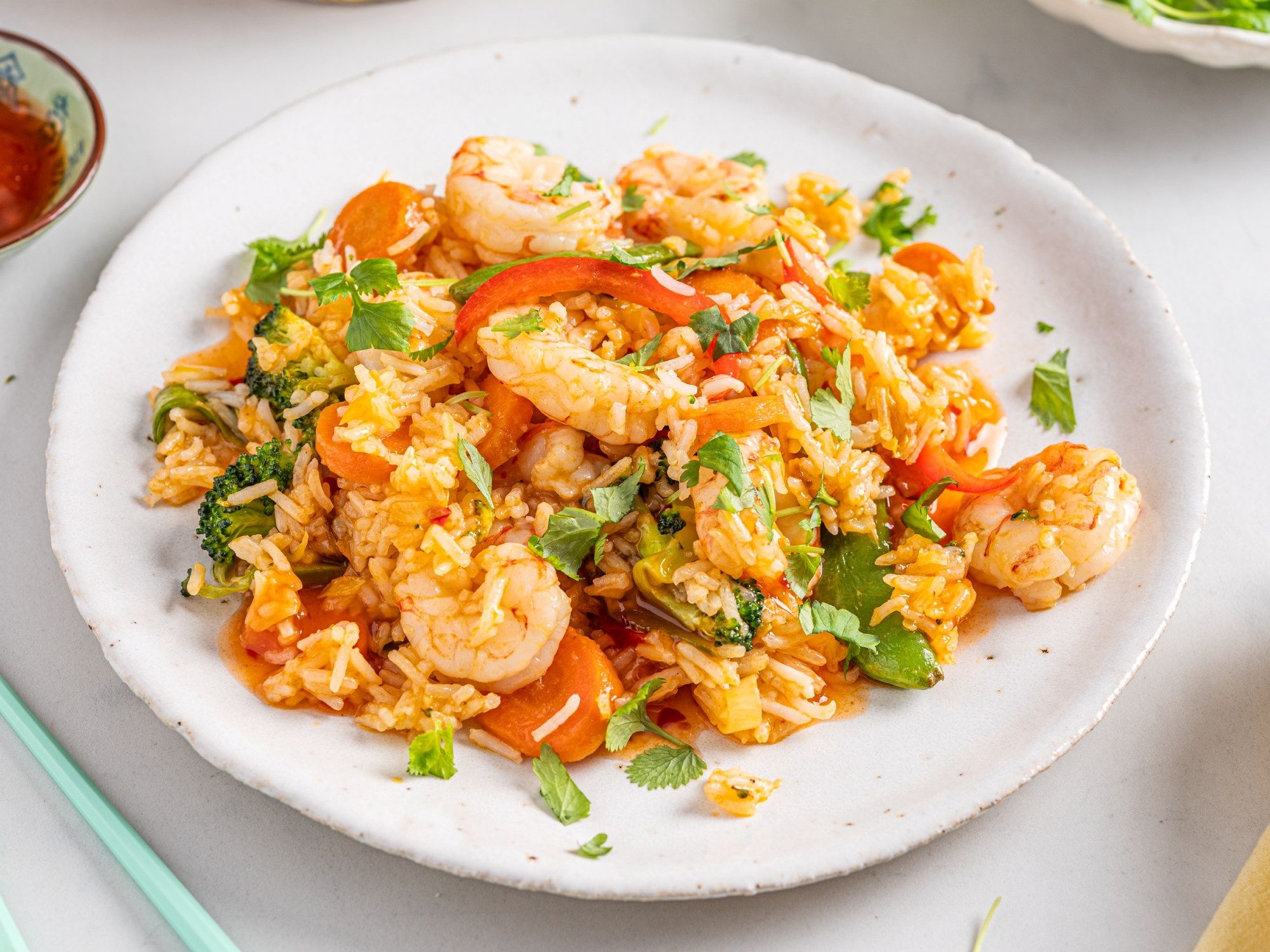 Wok med villreker, grønnsaker og koriander på en hvit tallerken