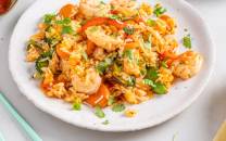 Wok med villreker, grønnsaker og koriander på en hvit tallerken