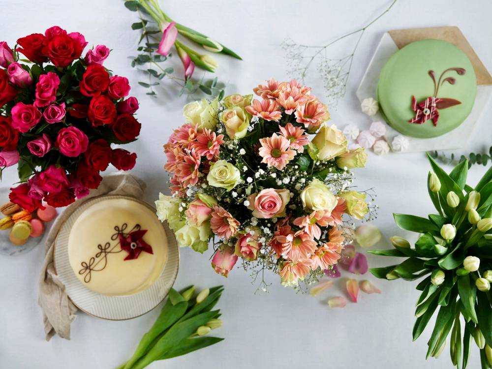 Et dekket langbord med blomsterbuketter og kaker sett ovenfra.