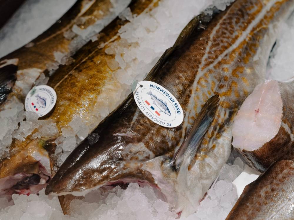 Ferske fisker på isen i en butikk, med en menyetikett som viser at de er fra MENY Løren.