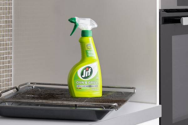 En grønn sprayflaske med merkevaren Lift står på en komfyr i et kjøkken.