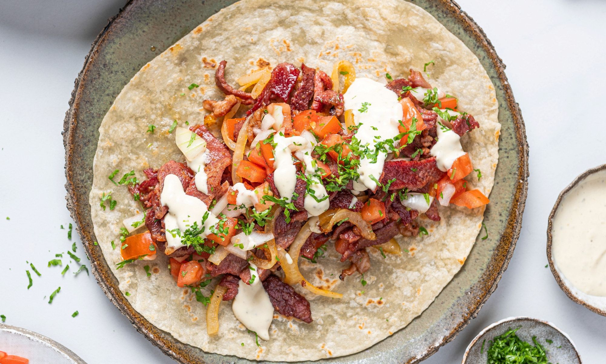 Stekt biffsnadder med grønnsaker og saus på en tallerken