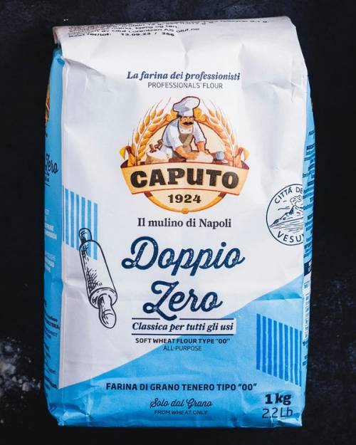 Pakkebilde av Caputo Doppio Zero mel, 1 kg, med italiensk tekst og logo, på en mørk bakgrunn.