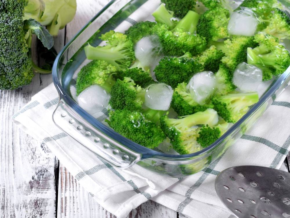 Brokkoli og isbiter i en glassform, klar til å fryses.