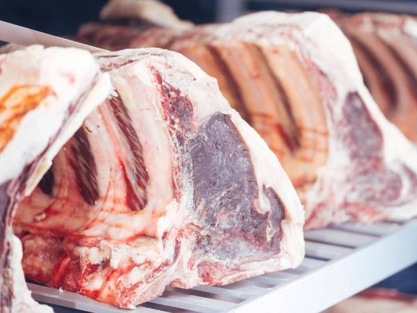 Kjøttstykker som ligger til tørk i et modningsskap.