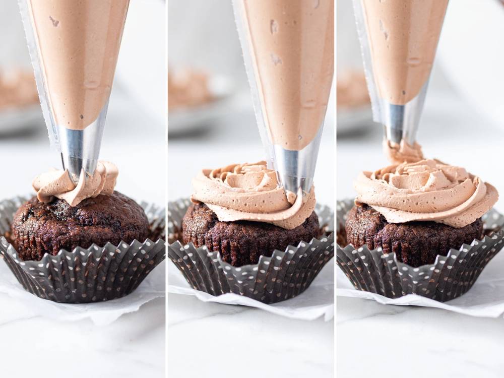 En kake med rosa krem og sprøyterose pynt som blir dekorert med en sprøytepose.