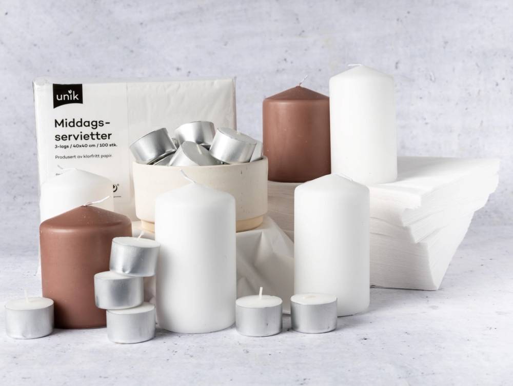 En rekke lys i ulike størrelser og farger, inkludert hvite og brune, plassert på en lys bakgrunn.