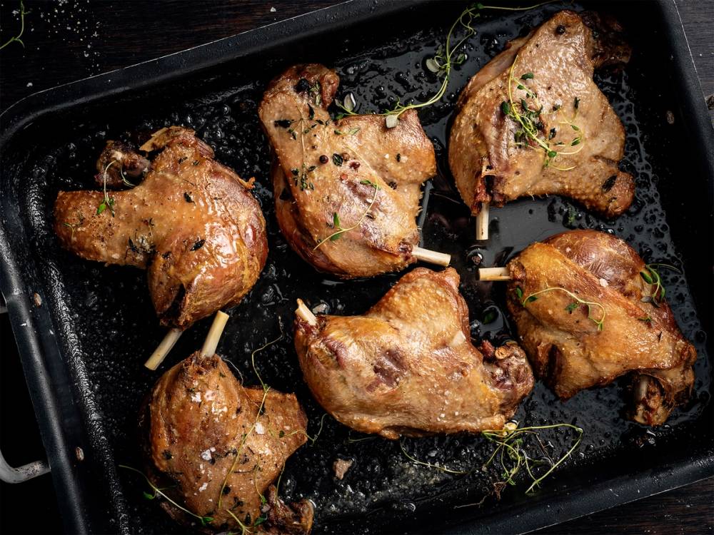 Andeconfit med sprøtt skinn og urter på en stekeplate