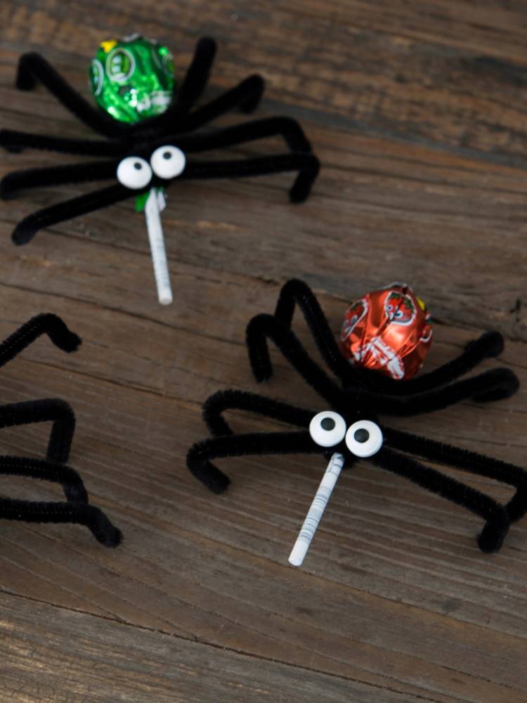 To kakerlakker med edderkoppbein og øyne laget av godteri på et treverk, som ser ut som edderkopper med kjærlighetsbudskap.