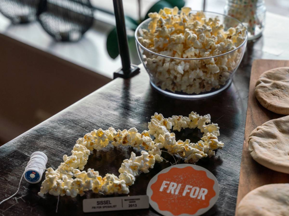 To kranser laget av popcorn ligger på et bord foran en stor bolle med popcorn, med en etikett som sier 'Fri for'.