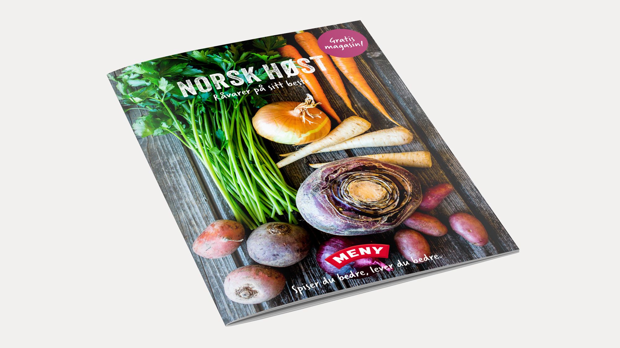 En kokebok med høsttema, dekorert med grønne urter, sopp, løk og rotgrønnsaker på forsiden.