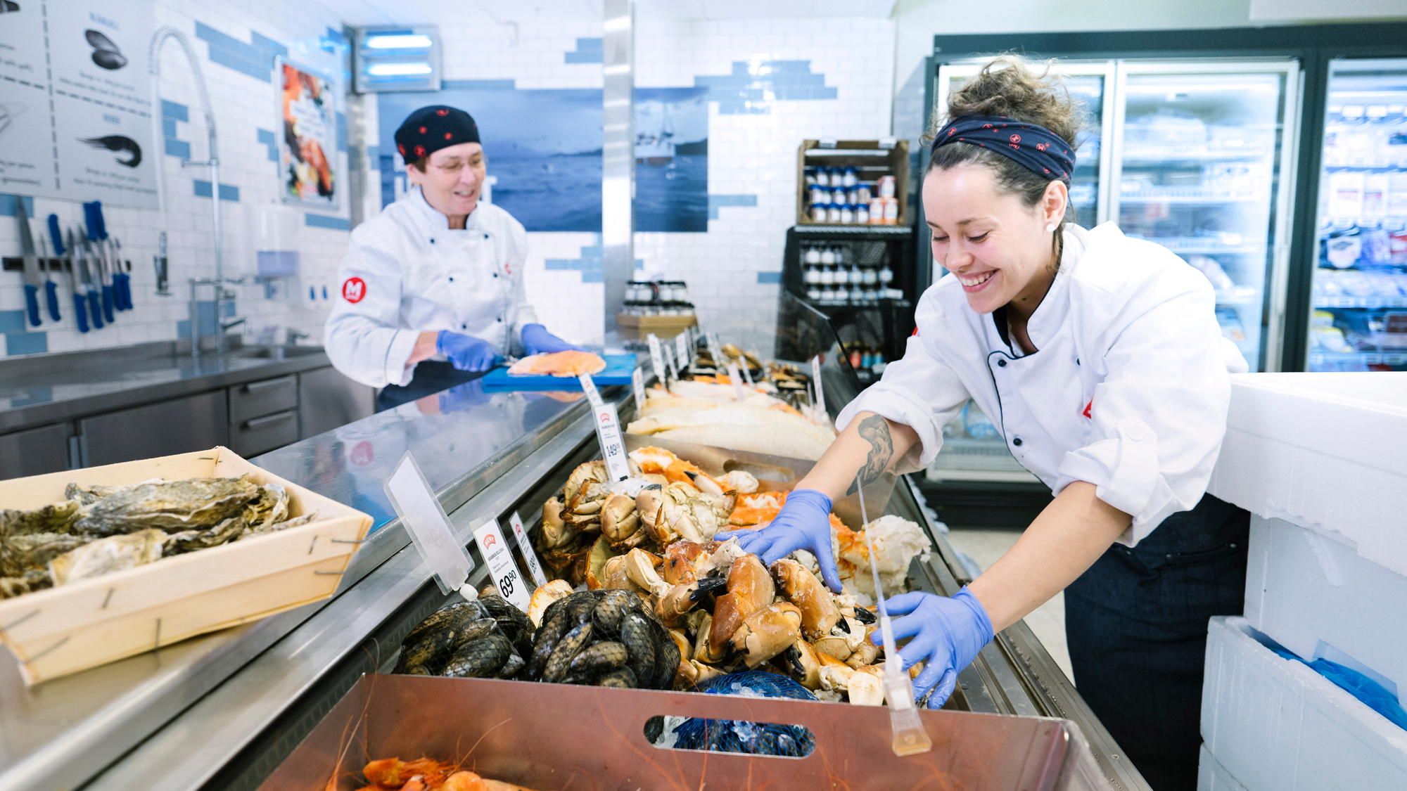 To matarbeidere gjør klar fiskedisken.