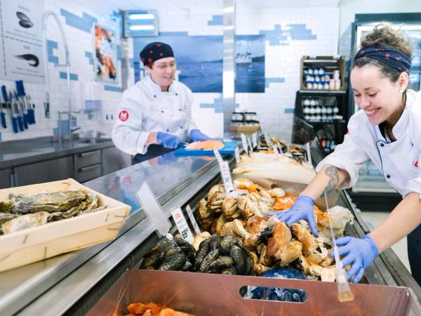 To matarbeidere gjør klar fiskedisken.