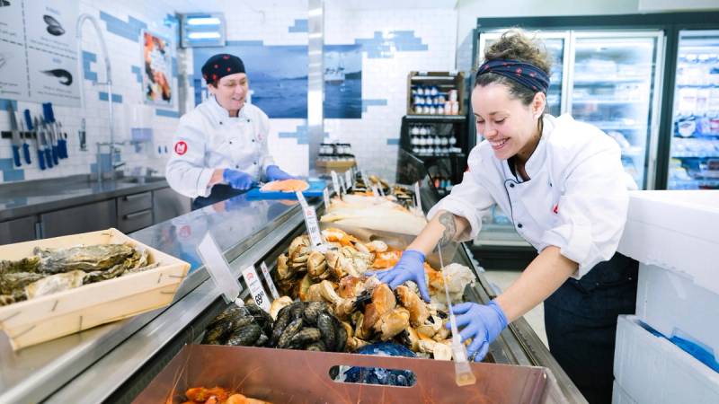 To matarbeidere gjør klar fiskedisken.