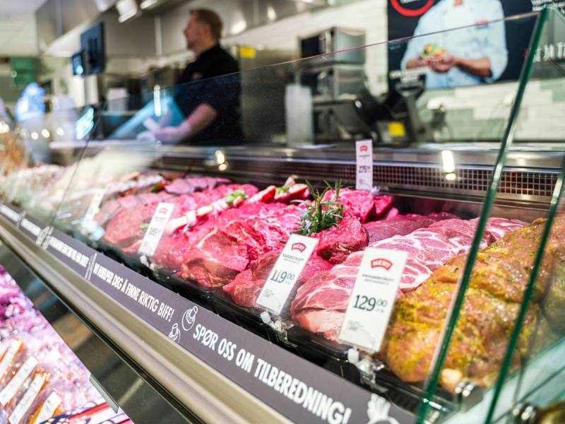 Kjøttvarer i en kjøledisk på en matbutikk i Oslo City, med priser og etiketter synlige.