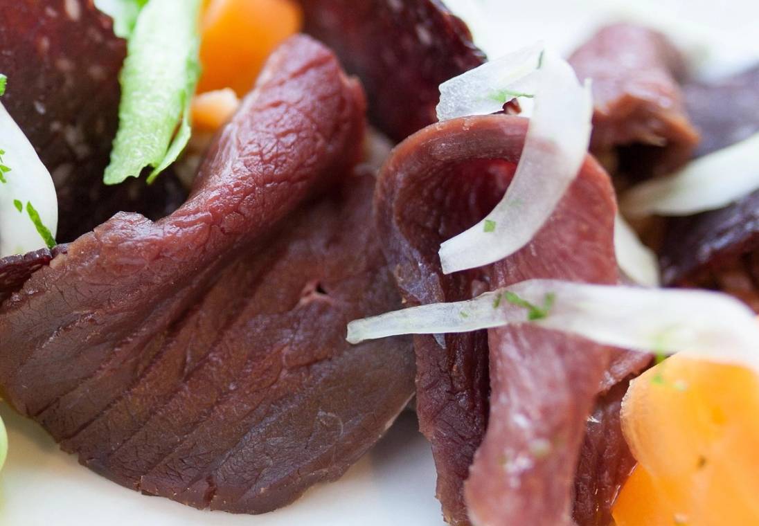 Reinsdyrkjøtt med plomme og løk på en tallerken