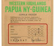 Pakke med kaffe med etikett som viser smaks- og styrkegrad, samt en signatur