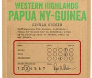 Pakke med kaffe med etikett som viser smaks- og styrkegrad, samt en signatur