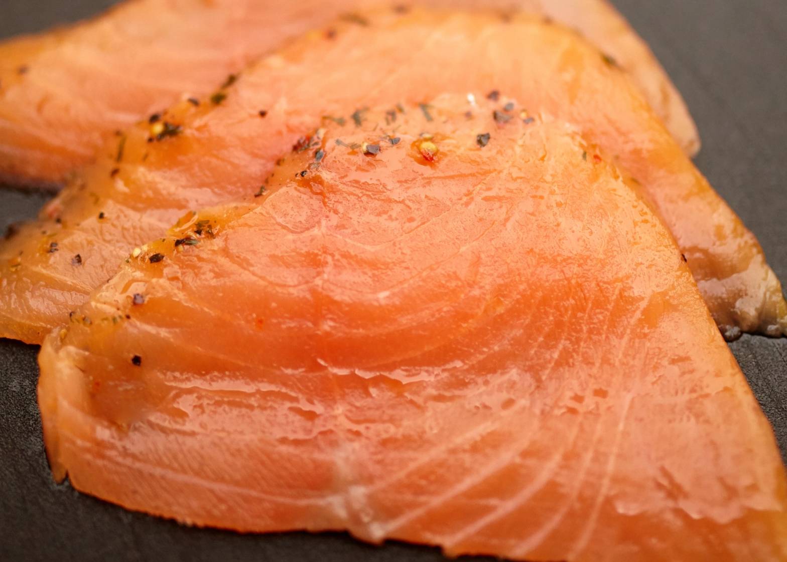 Skiver av gravlaks med røyketemperatur og krydder på toppen