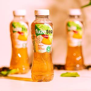 Fuze Tea Elderflower-flaske med te og smak av hyllebær, plassert foran to andre flasker av samme type.