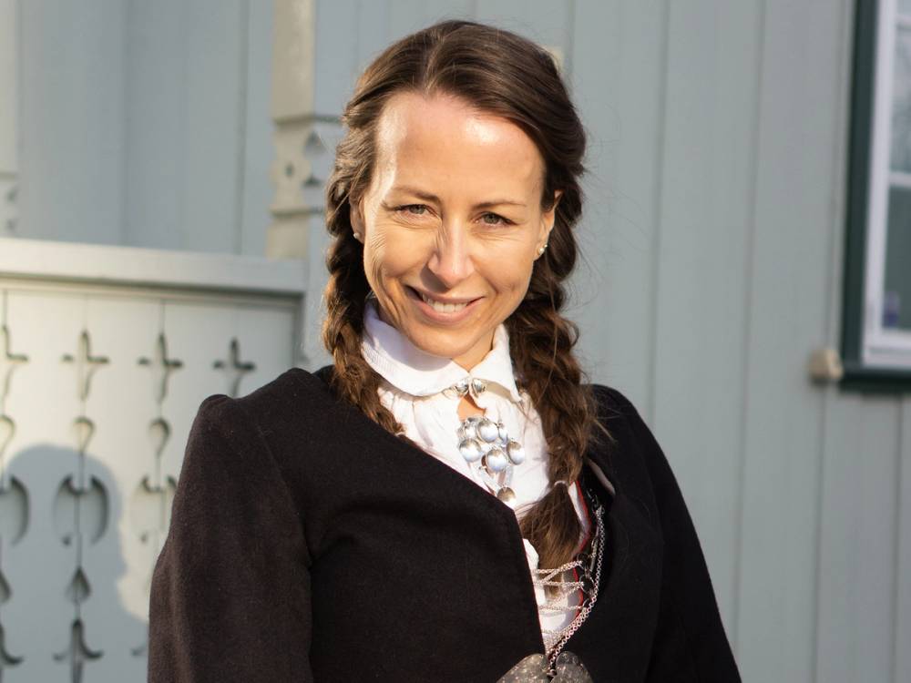 En jente med fletter som er kledd i bunad, sannsynligvis for 17. mai-feiring.