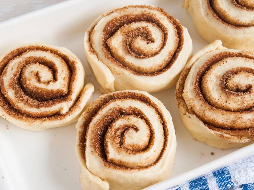 Kanelboller med sukker og kanel på en hvit tallerken