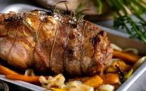 En klassisk lammestek servert på et fat med rotgrønnsaker og urter.