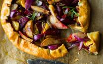Rustikk terte fylt med beter, rødløk og pære, med en sprø skorpe og friske urter på toppen.