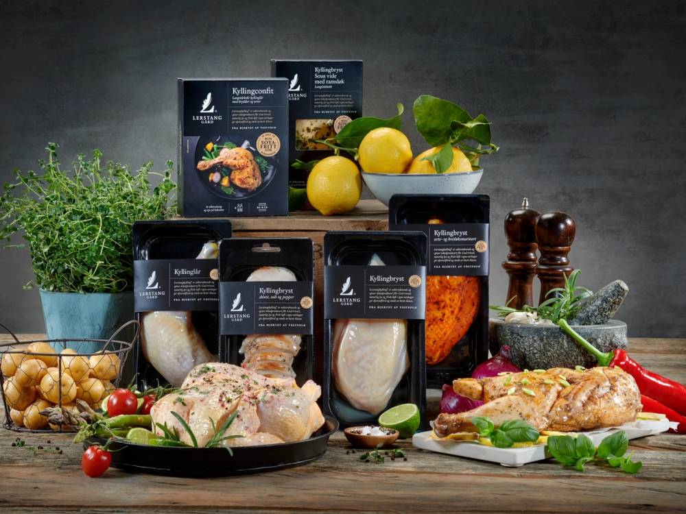 Et utvalg av soyafrie produkter, ferske grønnsaker og krydder på et kjøkkenbord, med en pott urter i bakgrunnen.