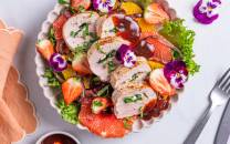 Svinefilet fylt med ost og spinat, servert med en salat av jordbær, appelsinbiter og grønn salat, pyntet med spiselige blomster.
