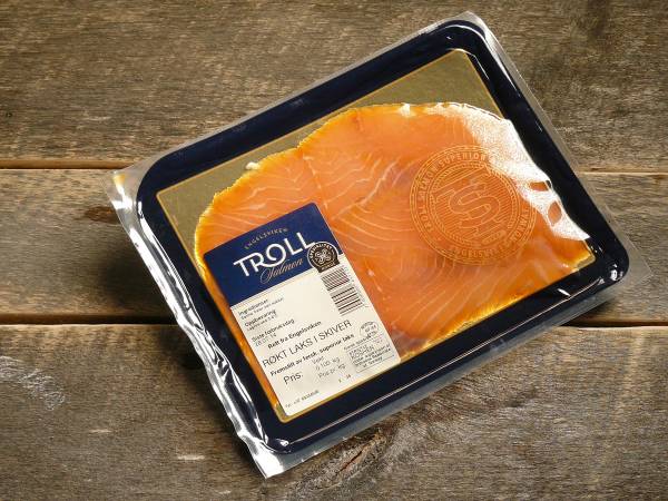 Pakke med laksefilet på en trebenk, med en etikett som viser at det er laks fra Troll.