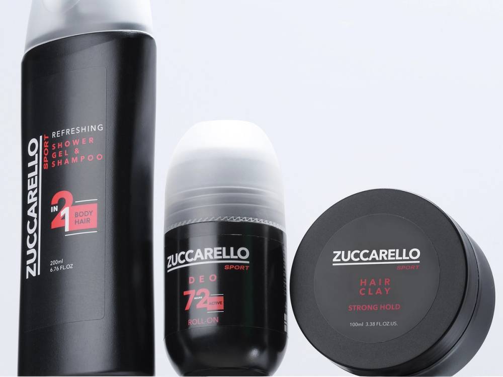 Tre skjønnhetsprodukter fra Zuccarello, inkludert en sprayflaske, en roll-on og en krukke, plassert på en hvit bakgrunn.